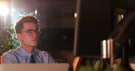 Image showing man working on computer in dark office