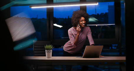 Image showing black businesswoman using a laptop in night startup office