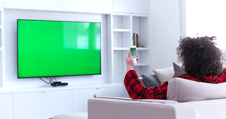 Image showing Young couple on the sofa watching television