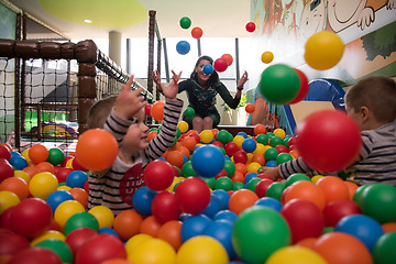 Image showing Young mom with her kids in a children\'s playroom