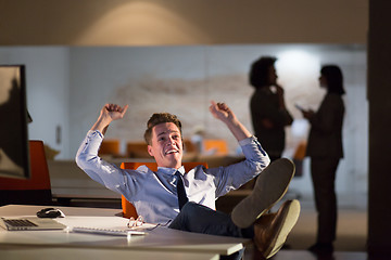 Image showing businessman sitting with legs on desk at office