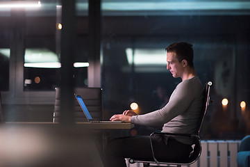 Image showing man working on laptop in dark office