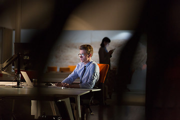 Image showing man working on computer in dark office