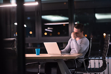 Image showing man working on laptop in dark office