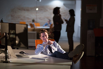 Image showing businessman sitting with legs on desk at office