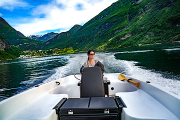 Image showing Woman driving a motor boat. Geiranger fjord, Beautiful Nature No