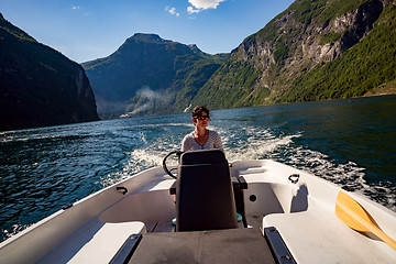 Image showing Woman driving a motor boat. Geiranger fjord, Beautiful Nature No