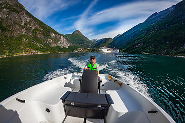 Image showing Man driving a motor boat. Geiranger fjord, Beautiful Nature Norw