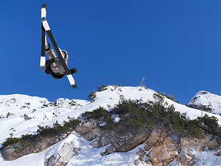 Image showing Extreme skier jumping from mountain blue sky in backgraund