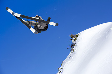 Image showing Extreme skier jumping from mountain blue sky in backgraund