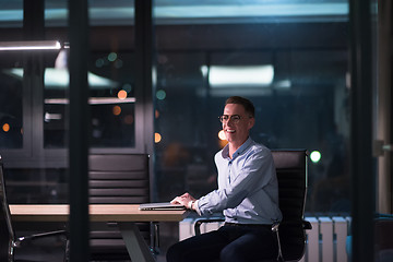 Image showing man working on laptop in dark office