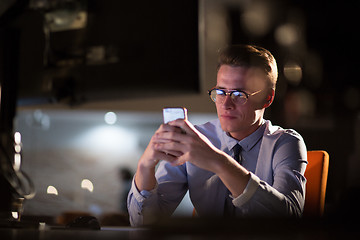 Image showing man using mobile phone in dark office