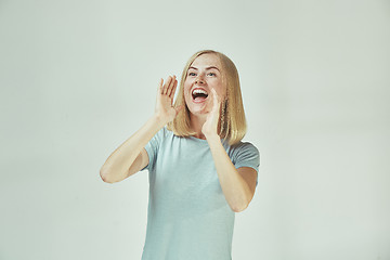 Image showing Isolated on pink young casual woman shouting at studio