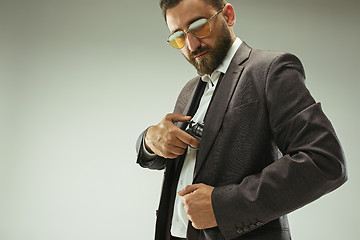 Image showing Businessman pulling the gun out of pocket