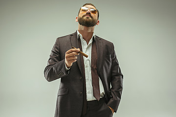 Image showing The barded man in a suit holding cigar