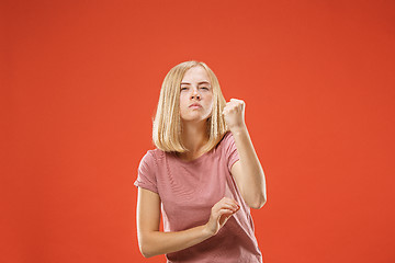 Image showing Portrait of an angry woman looking at camera isolated on a red background