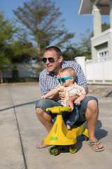 Image showing Father and baby son playing on the road at the day time.