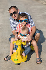 Image showing Father and two sons playing on the road at the day time.