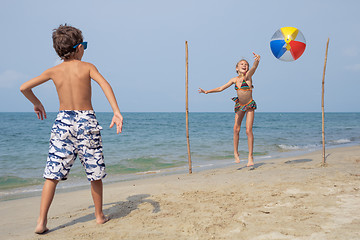 Image showing Two happy little children playing on the beach at the day time.