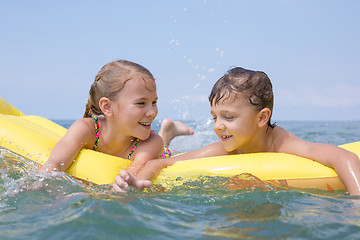 Image showing Two happy little children playing on the beach at the day time.