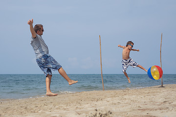 Image showing Father and son playing football on the beach