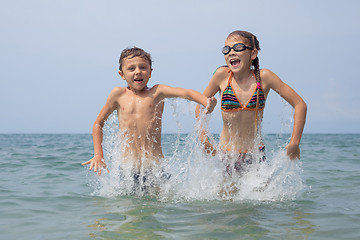 Image showing Two happy little children playing on the beach at the day time.