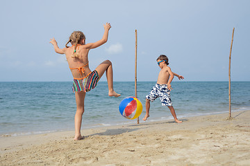 Image showing Two happy little children playing on the beach at the day time.