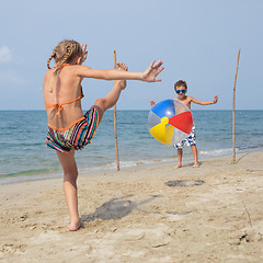 Image showing Two happy little children playing on the beach at the day time.