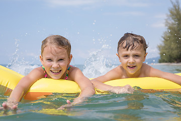 Image showing Two happy little children playing on the beach at the day time.