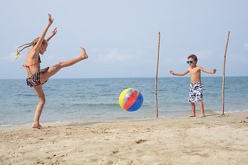 Image showing Two happy little children playing on the beach at the day time.
