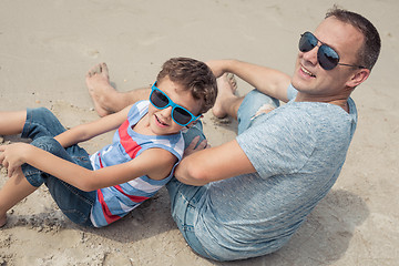 Image showing Father and son playing on the beach at the day time.