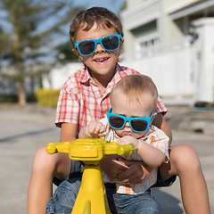 Image showing Two happy little children playing on the road at the day time.