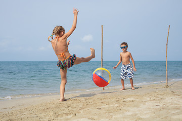 Image showing Two happy little children playing on the beach at the day time.