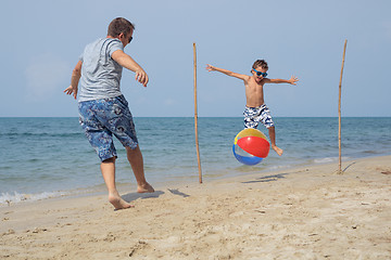 Image showing Father and son playing football on the beach