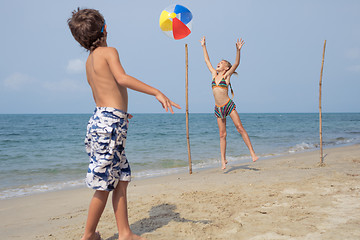 Image showing Two happy little children playing on the beach at the day time.