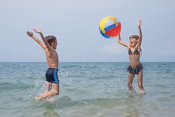 Image showing Two happy little children playing on the beach at the day time.