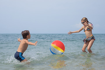 Image showing Two happy little children playing on the beach at the day time.