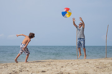 Image showing Father and son playing football on the beach