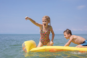 Image showing Two happy little children playing on the beach at the day time.