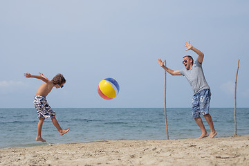 Image showing Father and son playing football on the beach