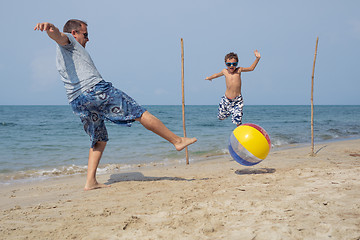 Image showing Father and son playing football on the beach