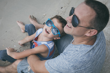 Image showing Father and son playing on the beach at the day time.