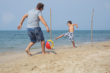 Image showing Father and son playing football on the beach