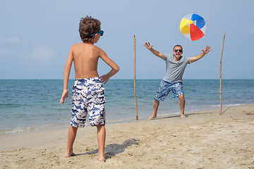 Image showing Father and son playing football on the beach