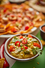 Image showing Close up on guacamole dip in bowl with various freshly made Mexican foods