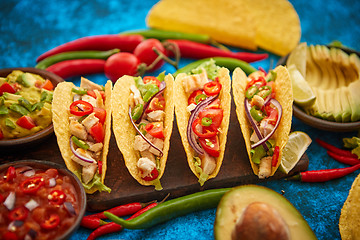 Image showing Mexican taco with chicken meat, jalapeno, fresh vegetables served with guacamole