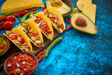 Image showing Mexican taco with chicken meat, jalapeno, fresh vegetables served with guacamole