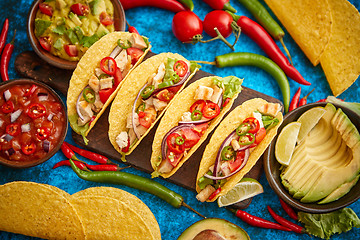 Image showing Mexican taco with chicken meat, jalapeno, fresh vegetables served with guacamole