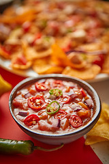 Image showing Close up on hot tomato dip in ceramic bowl with various freshly made Mexican foods