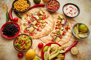 Image showing Freshly made healthy corn tortillas with grilled chicken fillet, big avocado slices